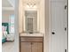 Bathroom with granite vanity, framed mirror, three-light fixture, and door at 113 Osier Dr, Mcdonough, GA 30252