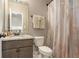 Stylish bathroom featuring a granite countertop, decorative mirror, and neutral-toned shower curtain at 113 Osier Dr, Mcdonough, GA 30252