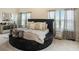 Elegant main bedroom with a round bed, luxurious bedding, and stylish mirrored accents at 113 Osier Dr, Mcdonough, GA 30252