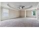 Spacious bedroom featuring neutral walls, plush carpeting, tray ceiling with fan, and ample natural light from two windows at 1340 Delo Ln, Cumming, GA 30041