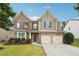 Charming two-story home features a brick facade, two-car garage, and well-maintained lawn at 1340 Delo Ln, Cumming, GA 30041