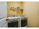 Functional laundry room features a side-by-side washer and dryer and shelving for storage at 1340 Delo Ln, Cumming, GA 30041