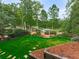 Well-manicured backyard featuring a lush green lawn, elegant landscaping, and a charming arbor, perfect for relaxation at 139 Grandmar Chase, Canton, GA 30115