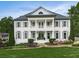 Elegant white brick home featuring a symmetrical design, columns, and lush landscaping at 139 Grandmar Chase, Canton, GA 30115