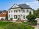Elegant two-story home with a white exterior, classic columns, manicured landscaping, and a welcoming front porch at 139 Grandmar Chase, Canton, GA 30115