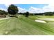 Scenic view of the golf course with meticulously maintained greens, sand traps, and mature trees under a clear blue sky at 139 Grandmar Chase, Canton, GA 30115
