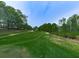 Lush green golf course view surrounded by mature trees and a clear blue sky, offering a serene and picturesque landscape at 139 Grandmar Chase, Canton, GA 30115
