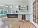 Open concept living room featuring hardwood floors, large windows, and a beverage center with a wine cooler at 139 Grandmar Chase, Canton, GA 30115