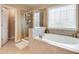 Bright bathroom featuring separate shower, corner tub and tiled walls at 4217 Brentwood Dr, Buford, GA 30518