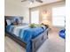 Well-lit bedroom with large windows, blue bedding, and carpet flooring at 4217 Brentwood Dr, Buford, GA 30518
