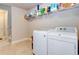 Well-organized laundry room with front load washer, dryer, and shelving for storage at 4217 Brentwood Dr, Buford, GA 30518