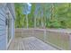 This back deck features wood floors, a light blue house, and a wooden railing at 6597 Ivy Log Dr, Austell, GA 30168