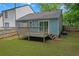 This backyard features a deck, a light blue house, green grass, and a wooden fence at 6597 Ivy Log Dr, Austell, GA 30168