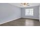Bedroom features wood-look floors, light blue walls, ceiling fan, and a window for natural light at 6597 Ivy Log Dr, Austell, GA 30168