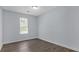 This bedroom features wood-look floors, light blue walls, a window, and white trim at 6597 Ivy Log Dr, Austell, GA 30168