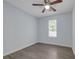This bedroom features a ceiling fan, window, light blue walls, and wood-look flooring at 6597 Ivy Log Dr, Austell, GA 30168