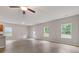 Bright living room featuring wood floors, a ceiling fan, and views of the outdoors through multiple windows at 3475 Ridge Hill Pkwy, Douglasville, GA 30135