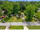 Aerial view of a property featuring a well-kept lawn, mature trees, and a peaceful residential street at 4002 Lindsey Dr, Decatur, GA 30035