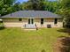 Spacious backyard showcasing the home's exterior, a small patio, and a well-maintained lawn at 4002 Lindsey Dr, Decatur, GA 30035