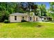 A well-kept single-story home with a green lawn, surrounded by mature trees creating a serene setting at 4002 Lindsey Dr, Decatur, GA 30035