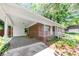 View of the house showing the covered carport and brick exterior, landscaped front yard with white picket fence at 844 Oak Nw St, Atlanta, GA 30318