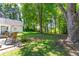 A view of the lush, green backyard, patio, and sunroom from the edge of the yard at 3335 Ashton Dr, Suwanee, GA 30024