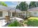 Backyard patio with rocking chairs, umbrella, and view of the sunroom and landscaped yard at 3335 Ashton Dr, Suwanee, GA 30024