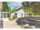 Side view of a charming, light brick home with a sunroom and a driveway lined with lush trees at 3335 Ashton Dr, Suwanee, GA 30024
