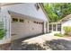 Attached garage with beige door, adjacent sunroom, and ample parking on the concrete driveway at 3335 Ashton Dr, Suwanee, GA 30024