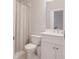 Bathroom features a toilet, white vanity, mirror, and shower with a patterned curtain at 3611 Ridgeway Rd, Duluth, GA 30096