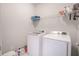 Laundry room with white washer and dryer, shelving, and storage for detergents at 3611 Ridgeway Rd, Duluth, GA 30096