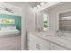 Bathroom with a marble vanity, dual sinks, and view of the bedroom with a queen bed at 435 Webb Dr, Norcross, GA 30071