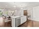 Island kitchen featuring stainless dishwasher and a dining area leading to a living space with coffered ceiling at 435 Webb Dr, Norcross, GA 30071