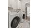 Laundry room featuring modern washer and dryer units and updated cabinets at 435 Webb Dr, Norcross, GA 30071