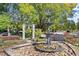 A serene park setting with a stone fountain, flower beds, mature trees, a bell, and park benches at 435 Webb Dr, Norcross, GA 30071