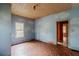 Room featuring a cloud motif, a vintage ceiling, worn floors, and natural light from the window at 1388 Metropolitan Se Ave, Atlanta, GA 30316