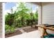Cozy porch with an iron fence surrounding a garden with plants and mulch and a wood table on a brick surface at 423 Burton Dr, Alpharetta, GA 30009