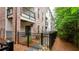 Townhome backyard featuring a black metal fence, a mulch flowerbed, and a view of the building exterior at 423 Burton Dr, Alpharetta, GA 30009