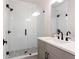 Modern bathroom featuring a tiled shower with glass door, stylish fixtures, and a gray vanity with white countertop at 423 Burton Dr, Alpharetta, GA 30009