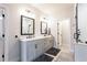 Bright bathroom featuring double vanity, quartz countertop, framed mirrors and a glass shower at 423 Burton Dr, Alpharetta, GA 30009