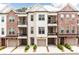 Exterior view of townhome with brick and siding, garages, balconies, and professionally landscaped front yards at 423 Burton Dr, Alpharetta, GA 30009
