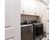 Bright laundry room featuring modern appliances, white cabinets, and ample storage space at 423 Burton Dr, Alpharetta, GA 30009