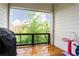 Covered porch with wood deck and view of trees and a nearby apartment building at 423 Burton Dr, Alpharetta, GA 30009