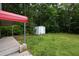 Spacious backyard features a storage shed and covered parking area amidst lush greenery at 743 New Hope Rd, Lawrenceville, GA 30046