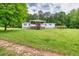 A single-story home features a front porch, wooden deck, green grass, and mature shade trees at 743 New Hope Rd, Lawrenceville, GA 30046