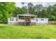 Charming single-story home features a large front porch, wooden deck, and a spacious lawn with mature trees at 743 New Hope Rd, Lawrenceville, GA 30046