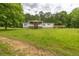 A single-story home features a front porch, wooden deck, green grass, and mature shade trees at 743 New Hope Rd, Lawrenceville, GA 30046