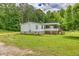 Exterior view of the home showing a covered front deck, grassy yard and surrounding trees at 743 New Hope Rd, Lawrenceville, GA 30046
