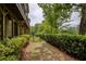 View of the townhome backyard, featuring a walkway, landscaping, and iron gate at 385 Windy Pines Trl, Roswell, GA 30075