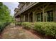 Lush backyard view showing townhome brick facade, mulched garden, and walkway with greenery at 385 Windy Pines Trl, Roswell, GA 30075